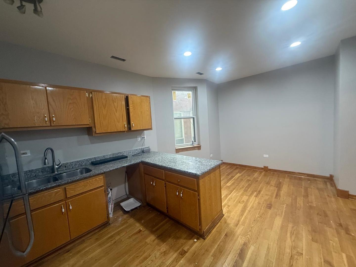 1756 West 35th Street, Unit 2R Chicago, IL 60609 - Photo 3 of 14 a kitchen with granite countertop a sink a stove cabinets and wooden floor