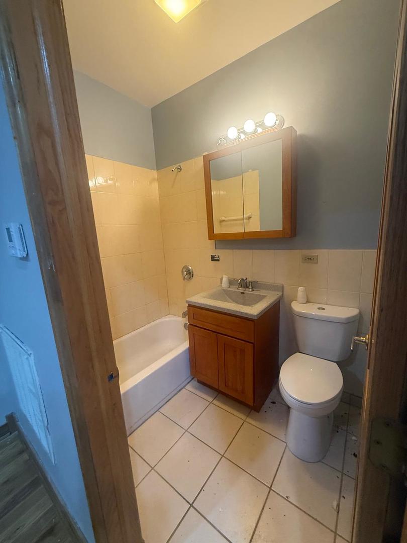 1756 West 35th Street, Unit 2R Chicago, IL 60609 - Photo 5 of 14 a bathroom with a granite countertop toilet a sink and a mirror