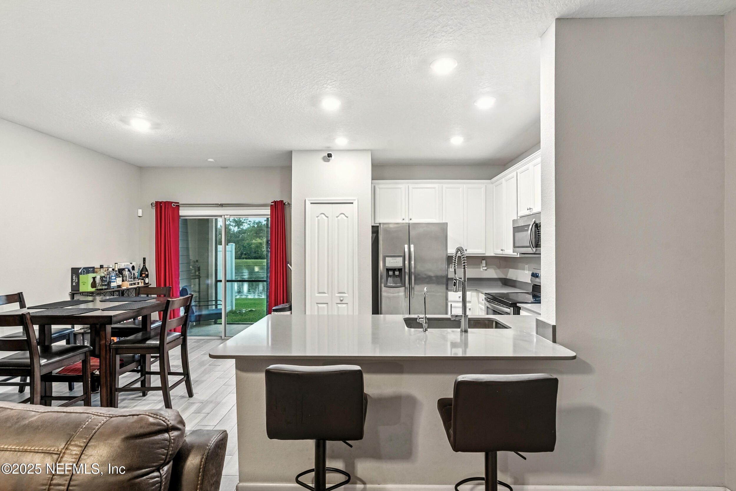 1330 Salt Ridge Avenue Jacksonville, FL 32218 - Photo 7 of 27 a kitchen with stainless steel appliances a dining table chairs and a refrigerator