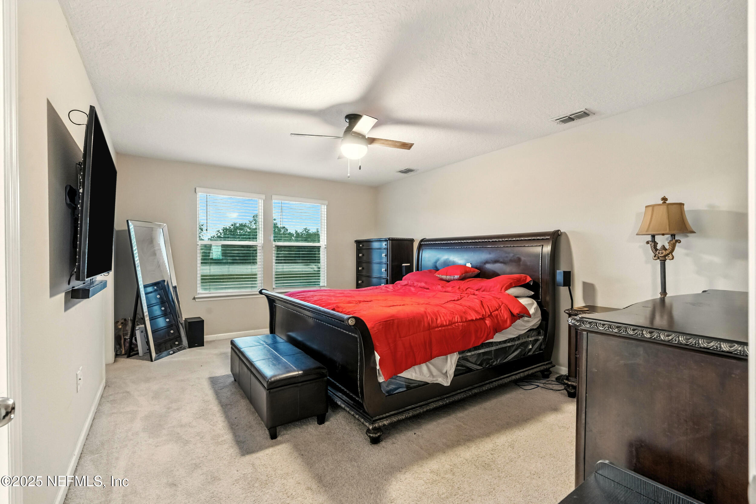 1330 Salt Ridge Avenue Jacksonville, FL 32218 - Photo 7 of 30 a spacious bedroom with a bed and a flat tv screen