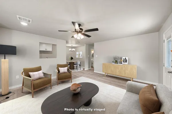 a living room with furniture and a ceiling fan