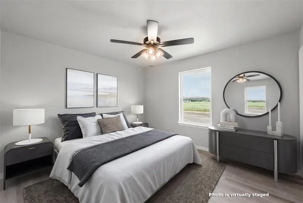 a bedroom with a bed a mirror on the wall and a window