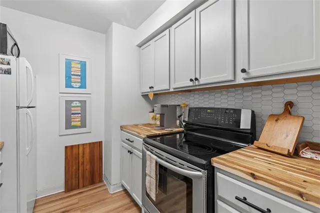 a kitchen with granite countertop white cabinets and stainless steel appliances