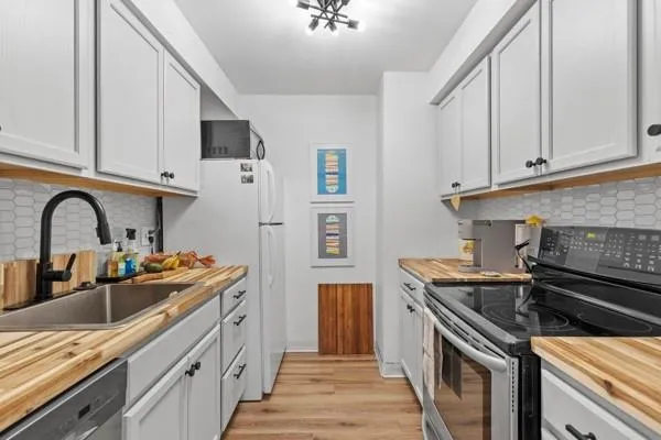 a kitchen with stainless steel appliances granite countertop a sink stove and cabinets