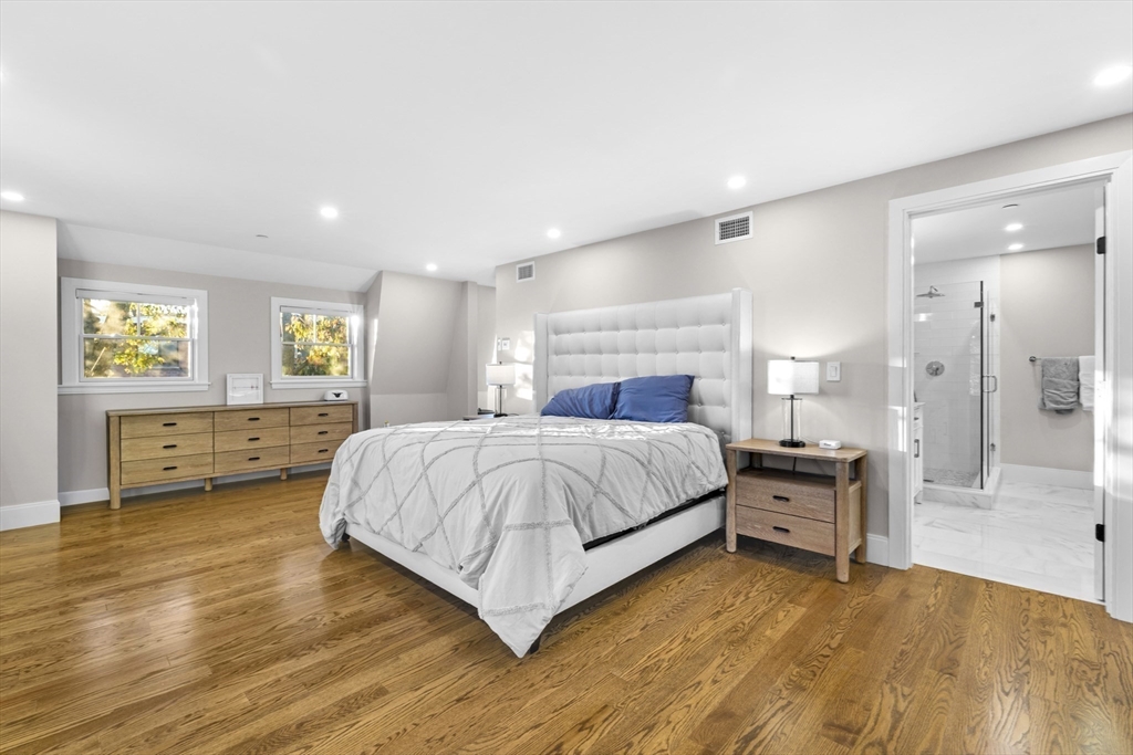 24 Selkirk Road, Unit 244 Boston, MA 02135 - Photo 15 of 31 a spacious bedroom with a bed and a dresser with wooden floor