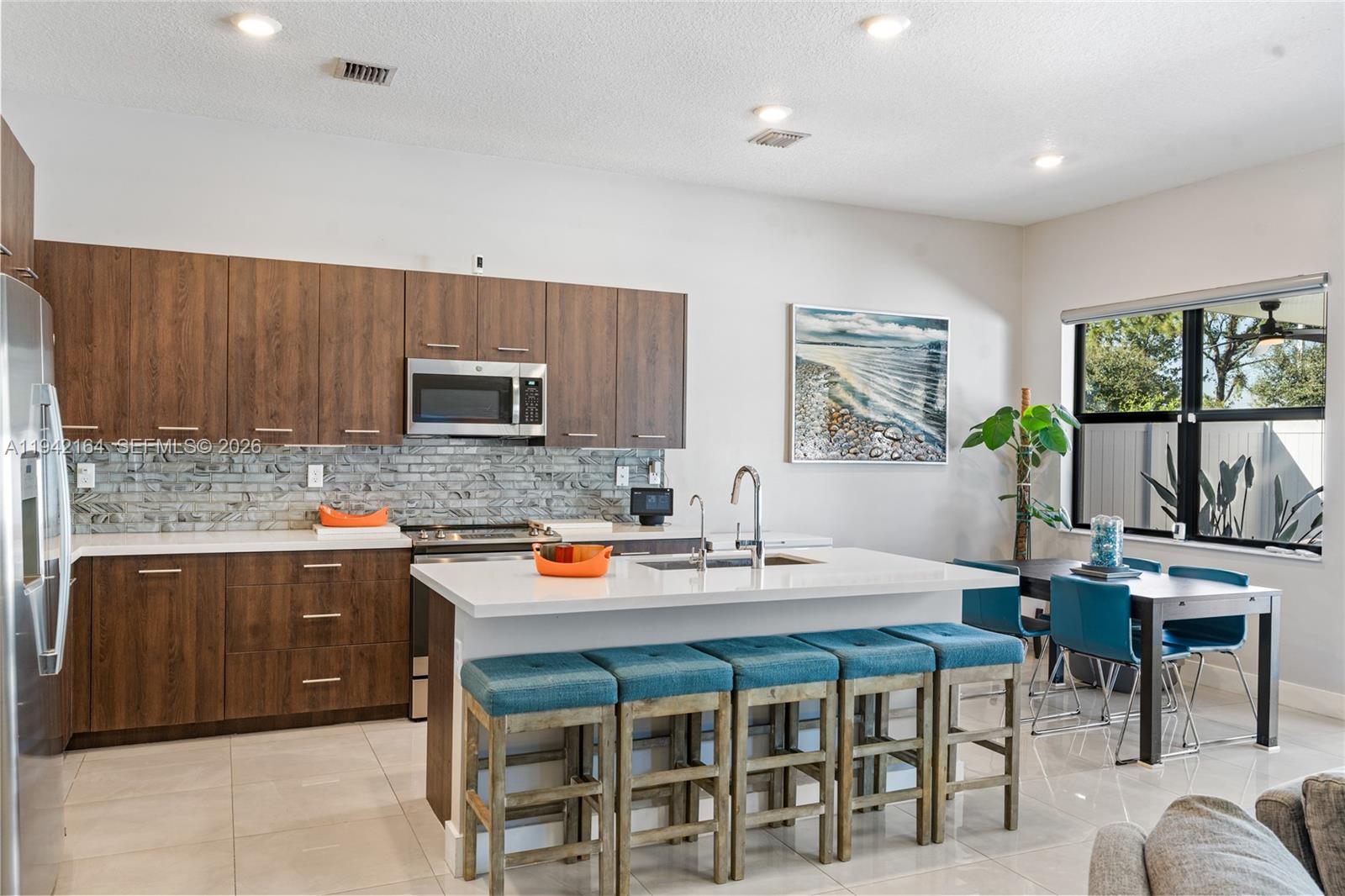 17375 Southwest 41st Street Miramar, FL 33029 - Photo 16 of 53 a kitchen with a table chairs microwave and cabinets