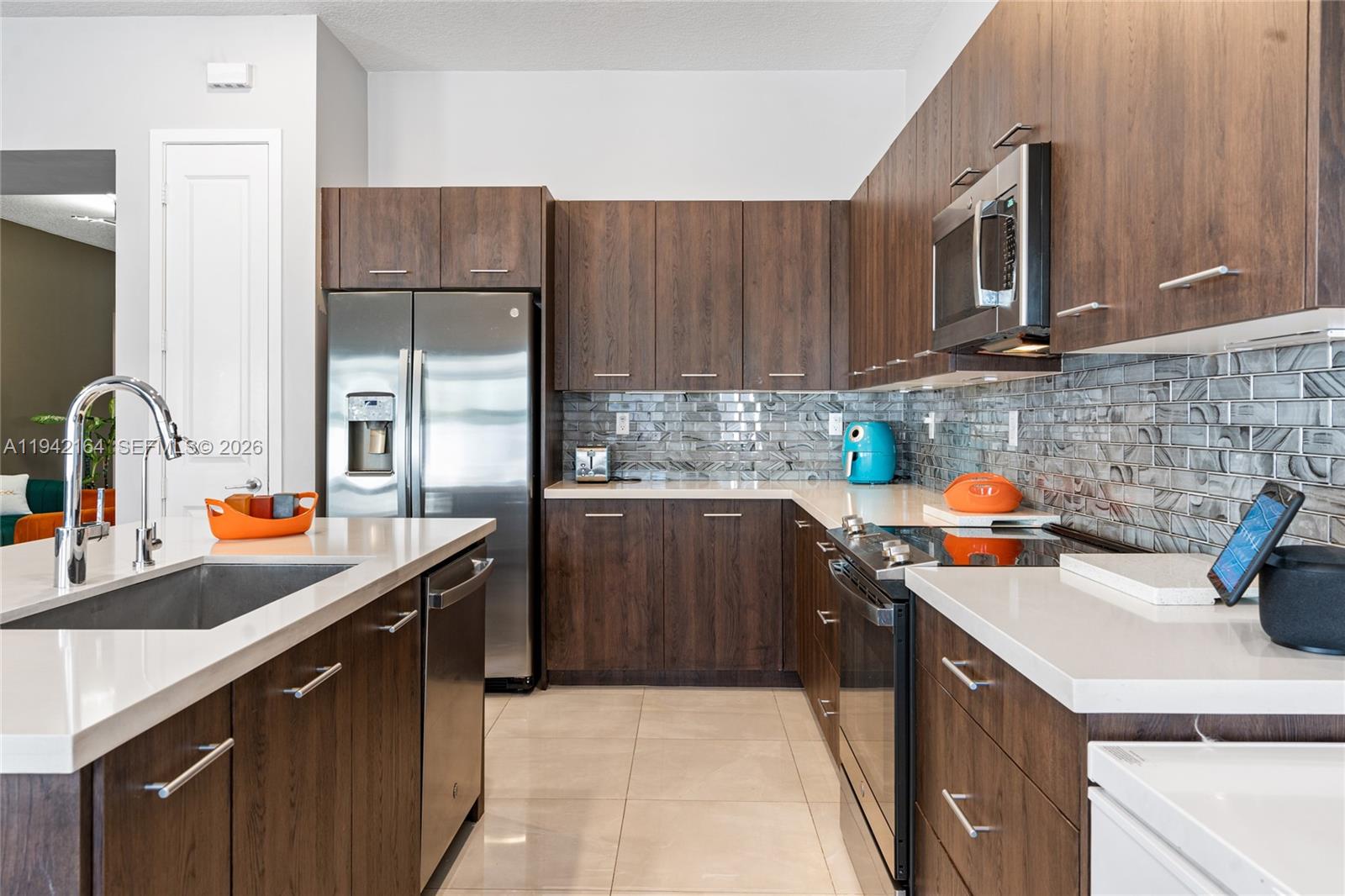 17375 Southwest 41st Street Miramar, FL 33029 - Photo 19 of 53 a kitchen with stainless steel appliances a sink a stove a refrigerator a sink a counter space and cabinets