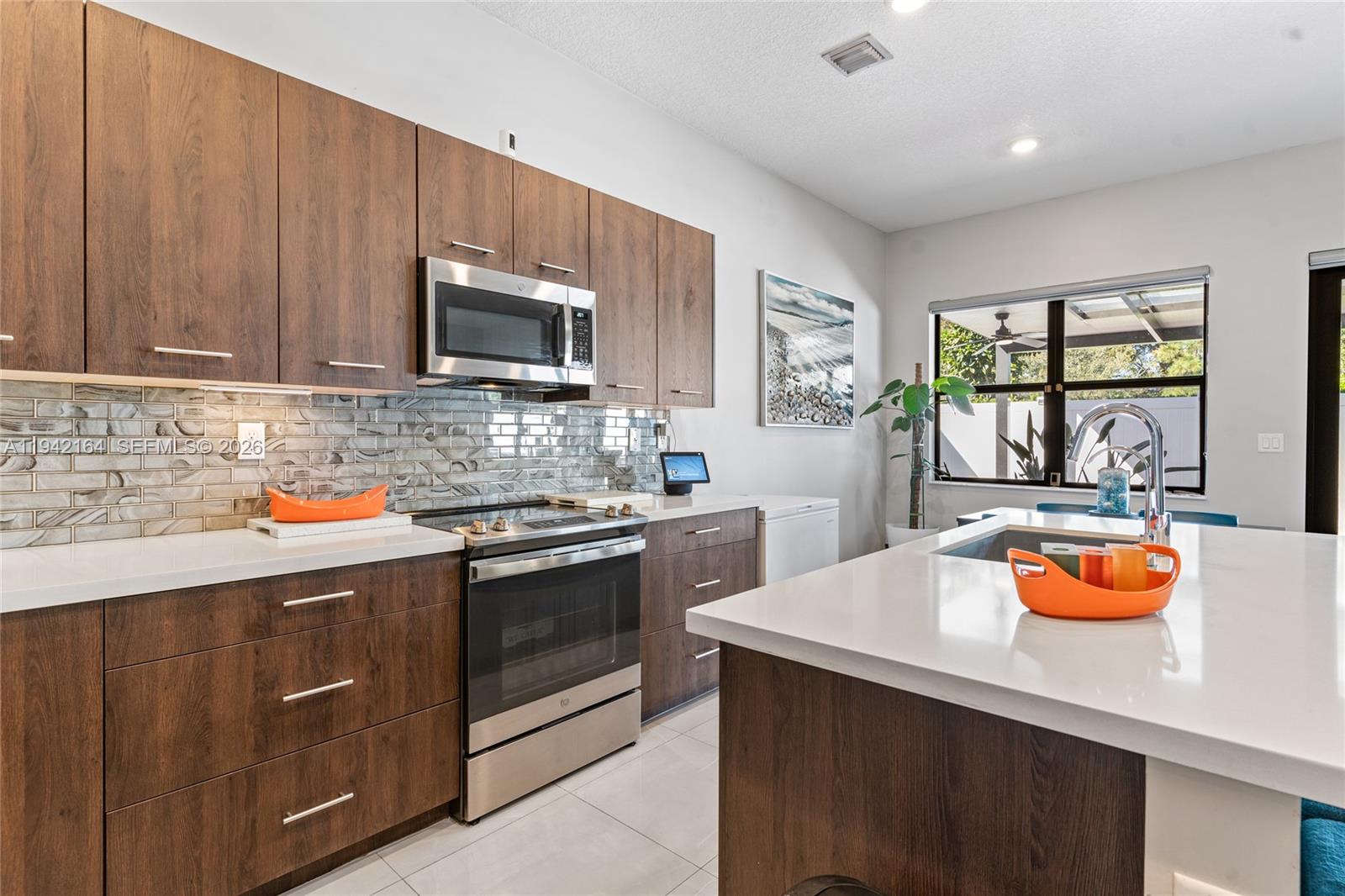 17375 Southwest 41st Street Miramar, FL 33029 - Photo 20 of 53 a kitchen with stainless steel appliances a stove a sink a microwave and cabinets