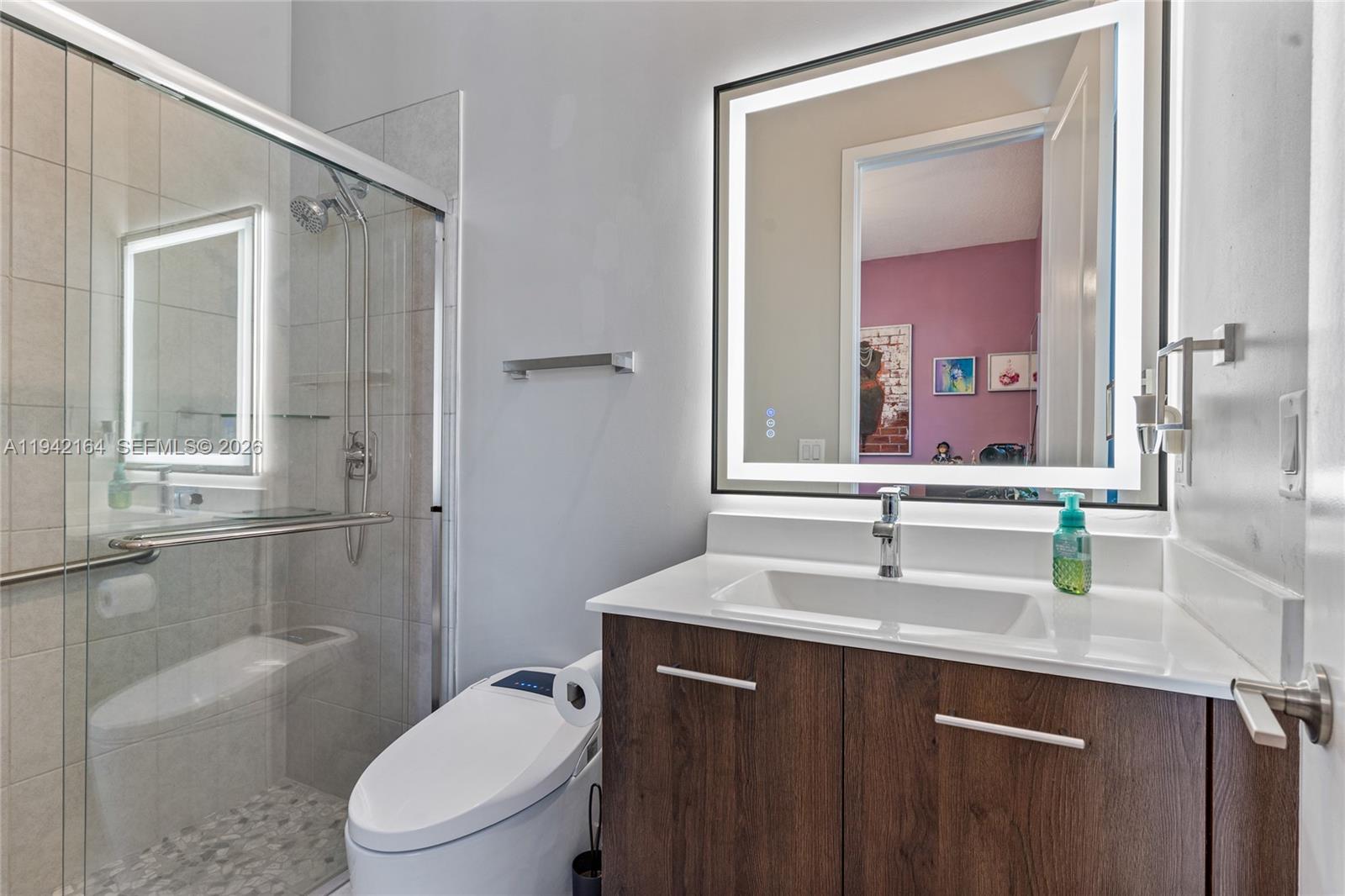 17375 Southwest 41st Street Miramar, FL 33029 - Photo 25 of 53 a bathroom with a granite countertop sink toilet a mirror and shower