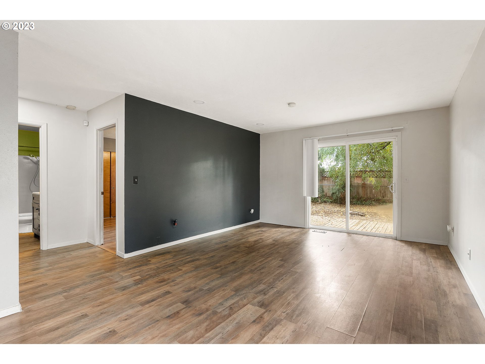 2720 Southeast Palmquist Road Gresham, OR 97080 - Photo 6 of 15 a view of an empty room with wooden floor and a window