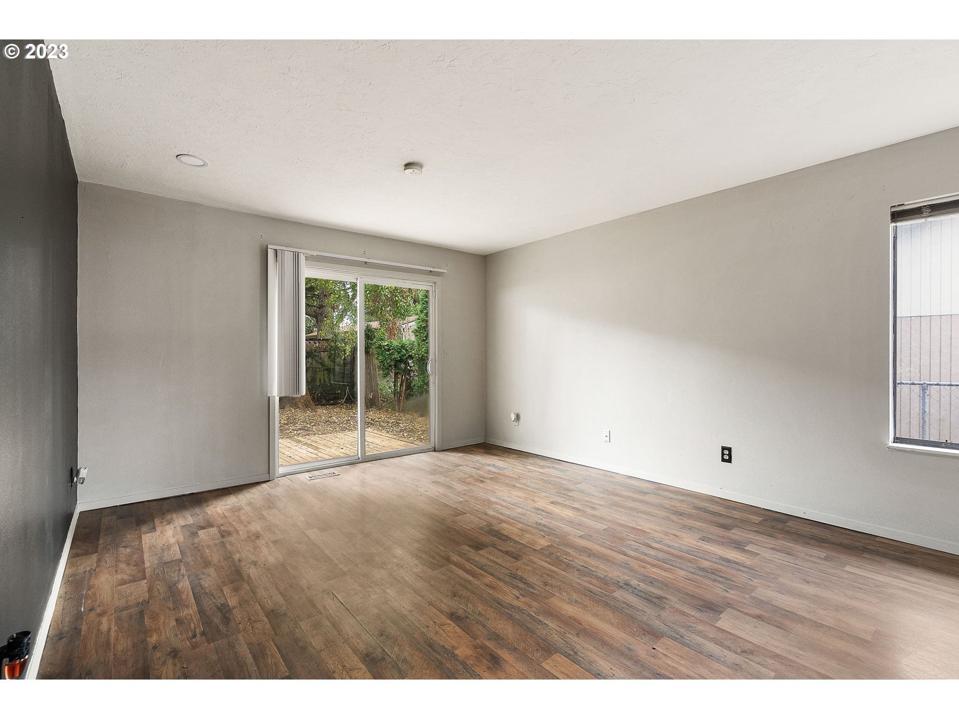 2720 Southeast Palmquist Road Gresham, OR 97080 - Photo 7 of 15 a view of an empty room with wooden floor and a window
