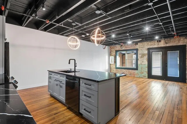 a kitchen with granite countertop a sink and wooden floor