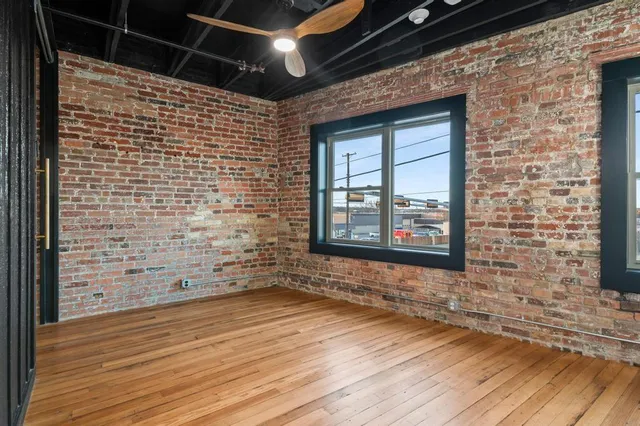 a view of a hallway with wooden floor and a kitchen