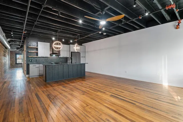 a view of kitchen with granite countertop window and wooden floor