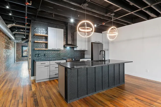 a kitchen with stainless steel appliances granite countertop a large stove a sink dishwasher and cabinets with wooden floor