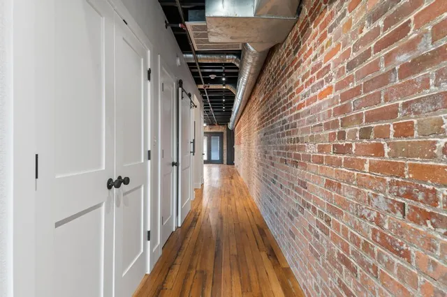 a view of a hallway with wooden floor and staircase