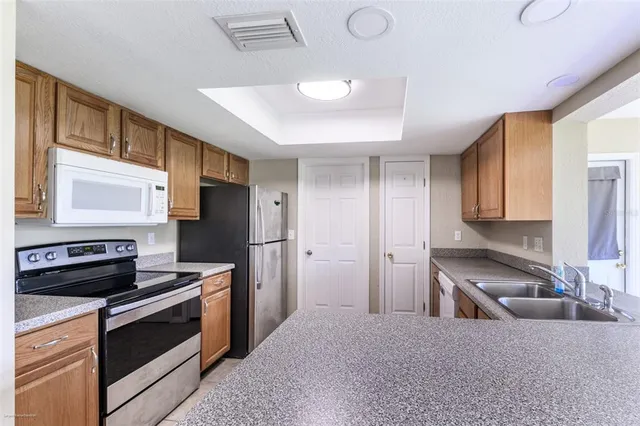a kitchen with stainless steel appliances granite countertop a sink stove and refrigerator
