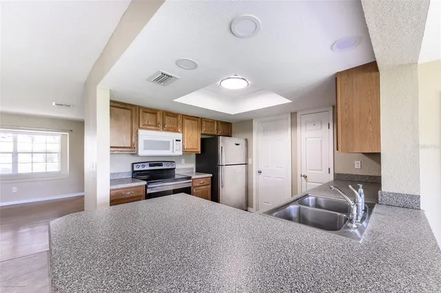 a kitchen with a sink a refrigerator and a stove top oven