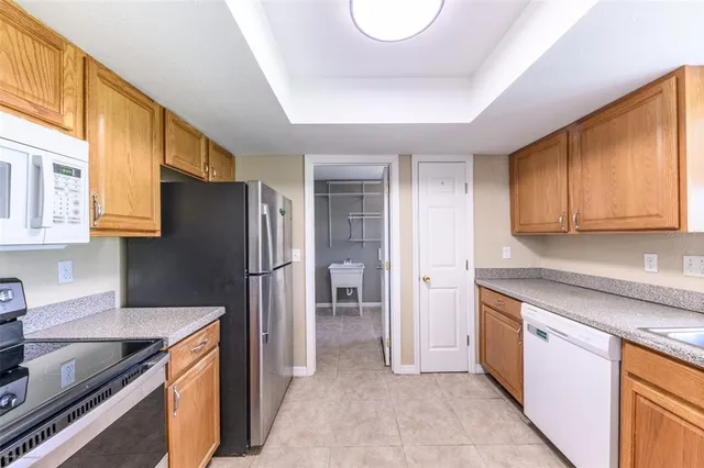 a kitchen with granite countertop cabinets stainless steel appliances and a window