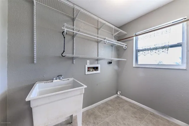 a view of an empty room with a window and a kitchen