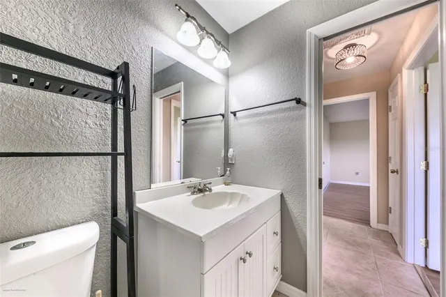 an empty room with wooden floor and a ceiling fan