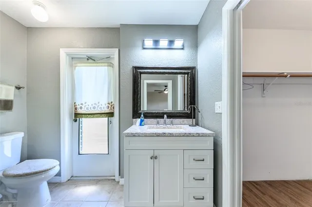 a view of a house with a big yard potted plants and large tree