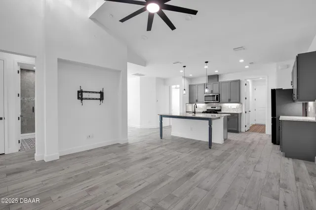 an empty room with windows and fan