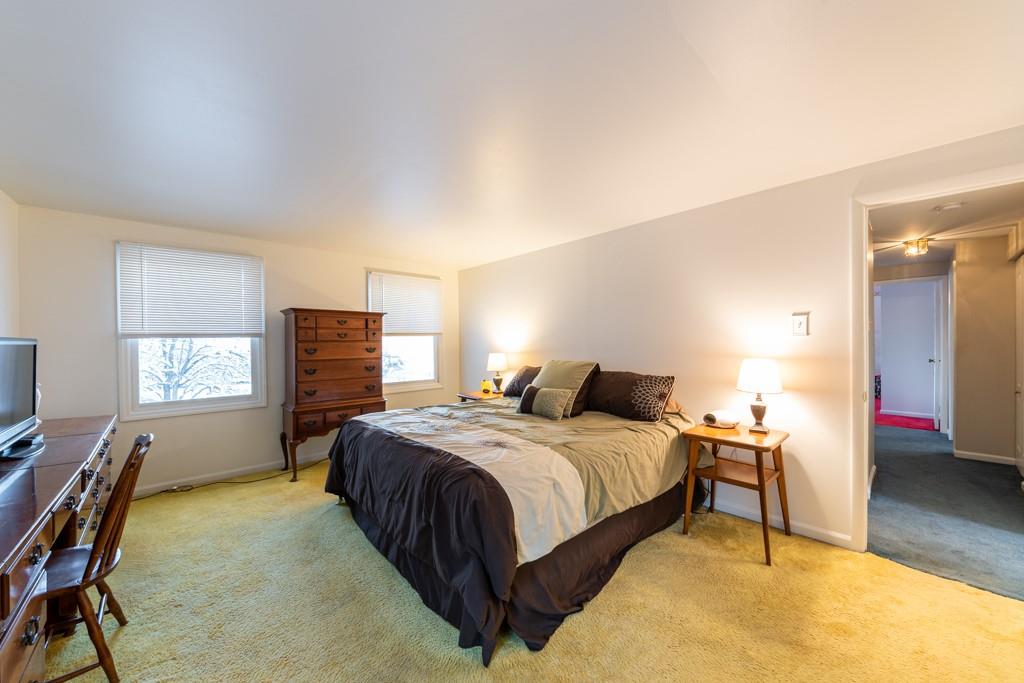 614 Ravencrest Road Pittsburgh, PA 15215 - Photo 13 of 25 a bedroom with a bed and a table in it with wooden floor