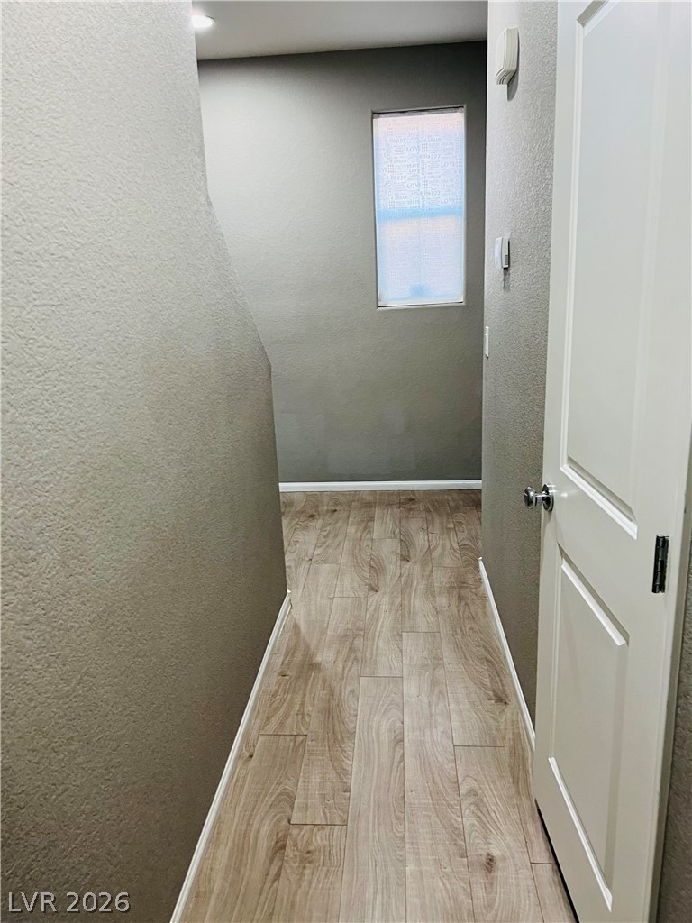 9325 Keystone Ridge Avenue Las Vegas, NV 89148 - Photo 3 of 17 A well-lit corridor boasts durable wood flooring and smooth walls, guiding residents to comfortable living spaces.