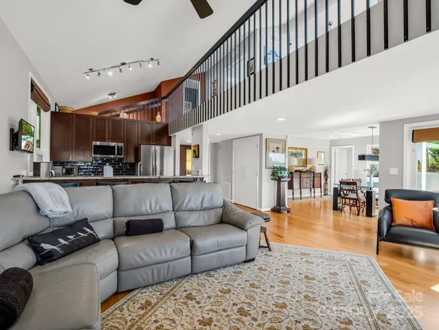 a view of a dining room and livingroom with furniture wooden floor a chandelier