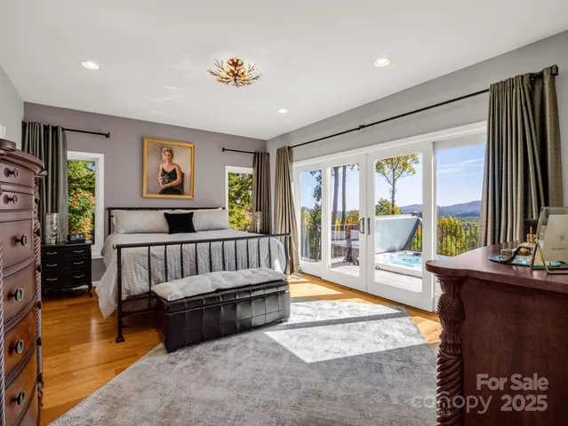 a bedroom with a bed and large windows