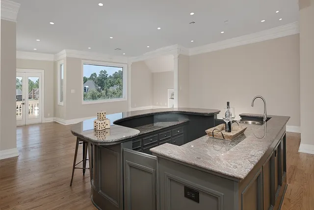 a kitchen with a sink dishwasher and a stove with wooden floor