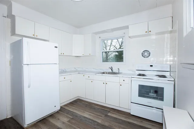a kitchen with cabinets stainless steel appliances a sink and a window