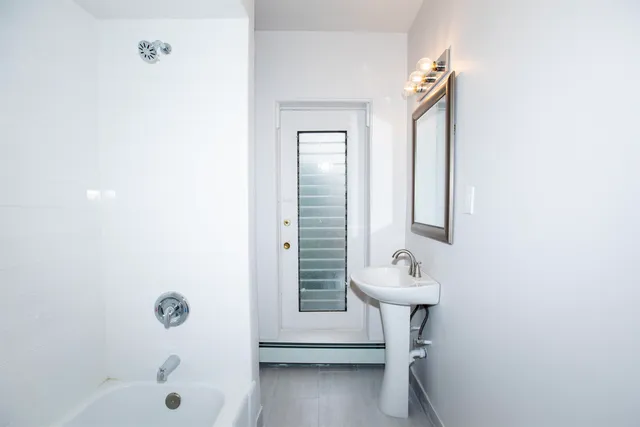 a bathroom with a sink a mirror and a bathtub