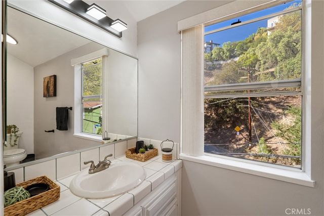 a bathroom with a sink mirror and window