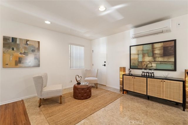 a living room with furniture a flat screen tv and a window