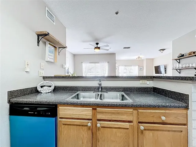a kitchen with granite countertop a sink a stove and cabinets