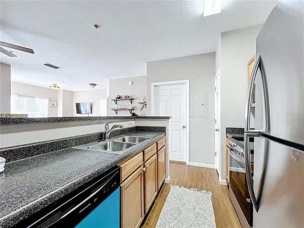 a kitchen with granite countertop a sink stove and refrigerator