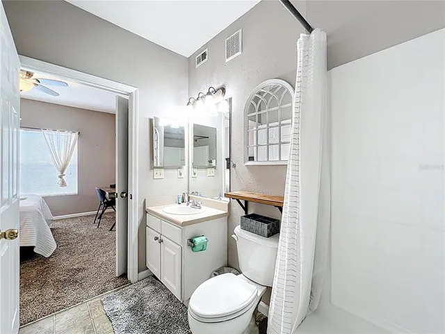 a bathroom with a toilet a sink and mirror