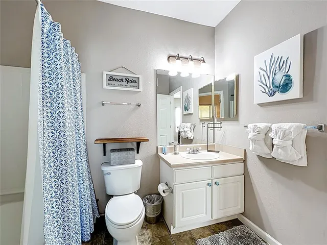a spacious bathroom with a toilet sink and mirror