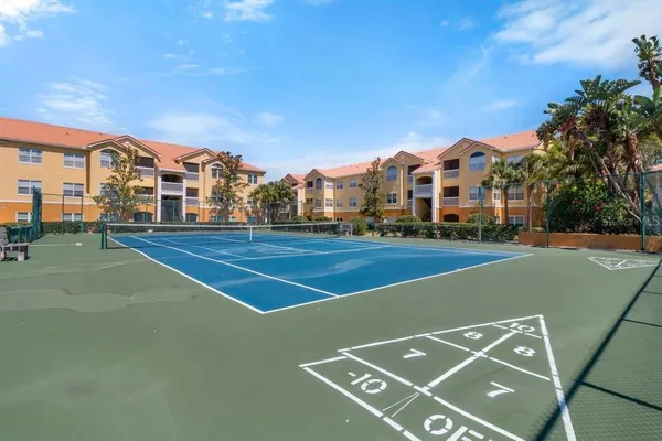 a view of a tennis ground with large trees