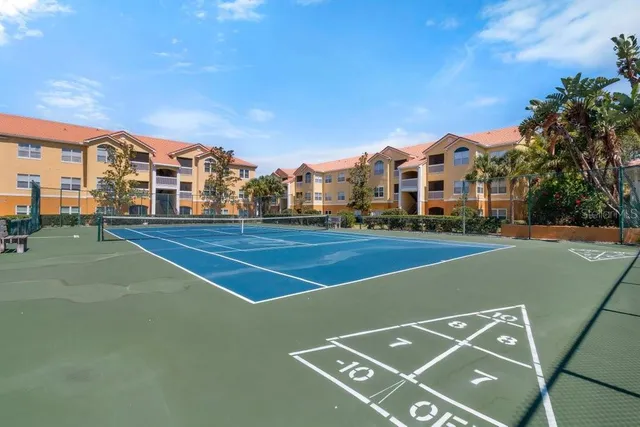 a view of a tennis ground with large trees