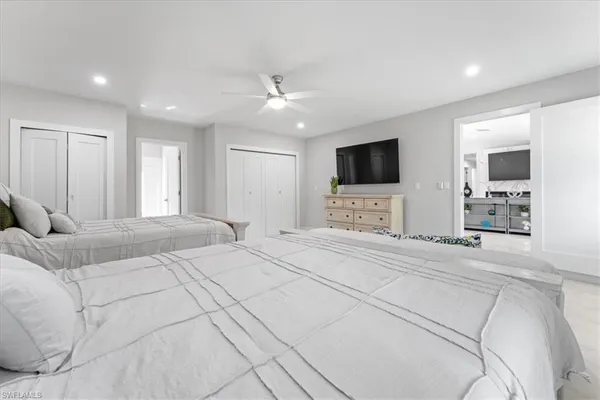 a spacious bedroom with a large bed and a flat screen tv