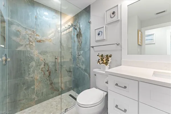a bathroom with a sink a toilet and shower