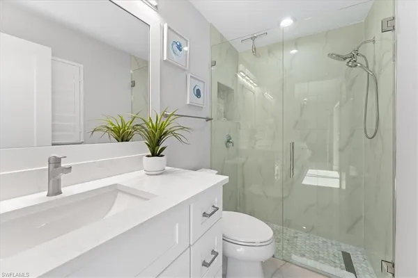 a bathroom with a sink a toilet and shower