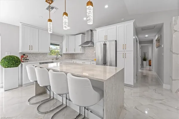 a kitchen with stainless steel appliances granite countertop a table chairs stove and refrigerator