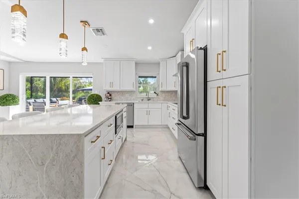 a kitchen with stainless steel appliances granite countertop a refrigerator and a sink