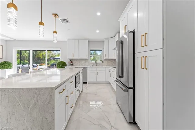 a kitchen with stainless steel appliances granite countertop a refrigerator and a sink