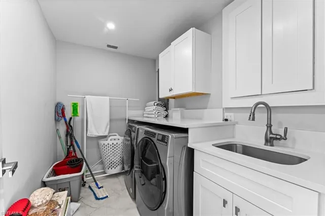 a utility room with sink dryer and washer