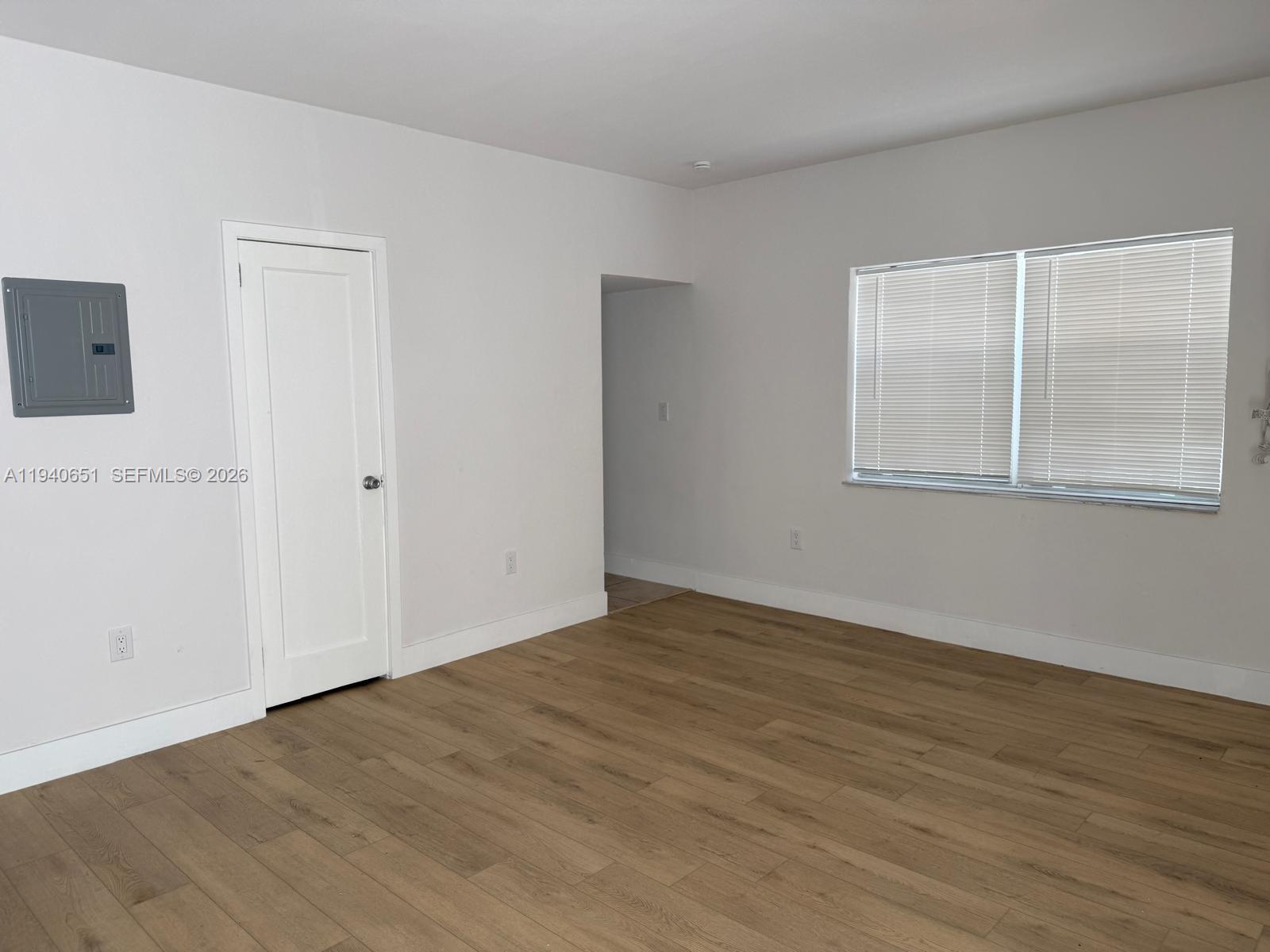 7611 Harding Avenue, Unit 5 Miami Beach, FL 33141 - Photo 4 of 15 an empty room with wooden floor and windows